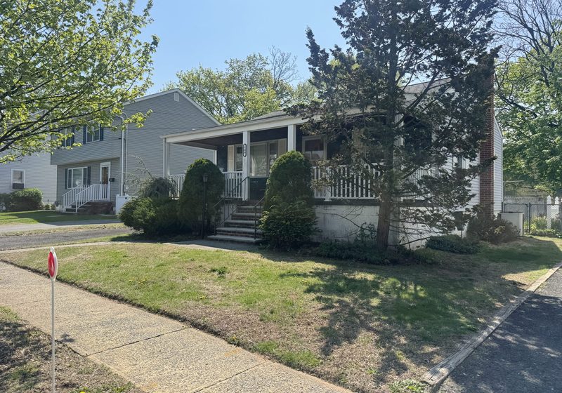 Home with a covered front porch on a corner lot in Dunellen, NJ
